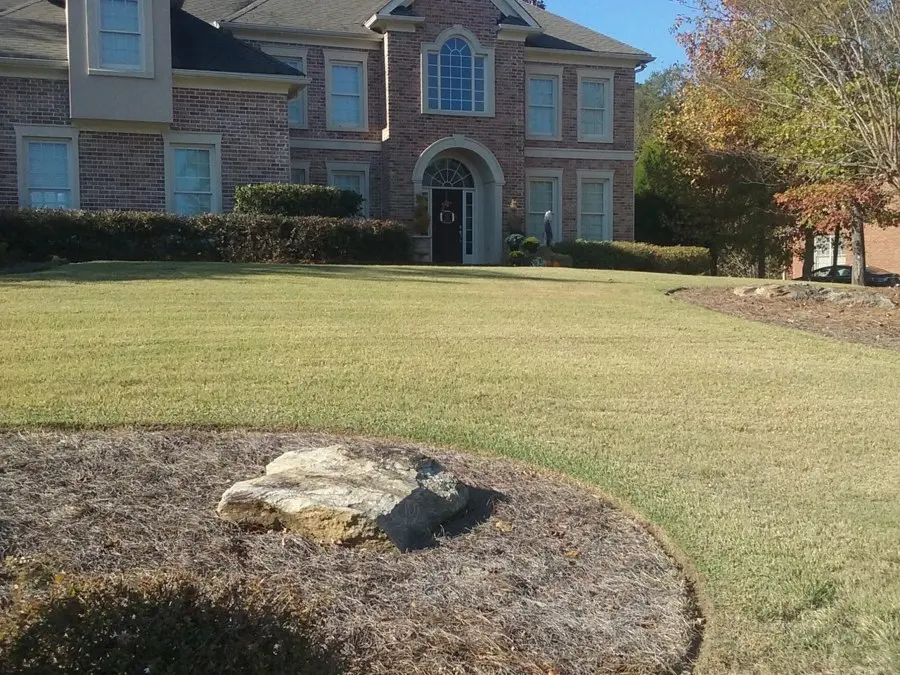 Cleared lawn and bed in front of a brick house